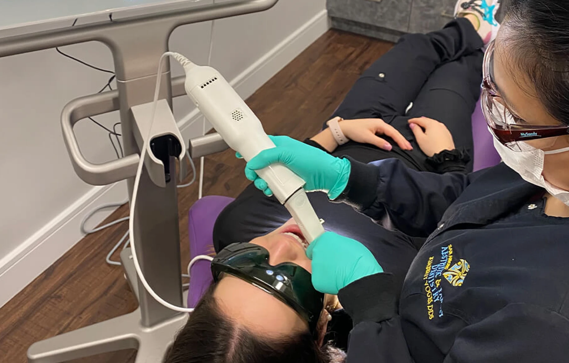 A woman receiving dental care and getting her teeth cleaned in a dentist's office, with a radiant smile.