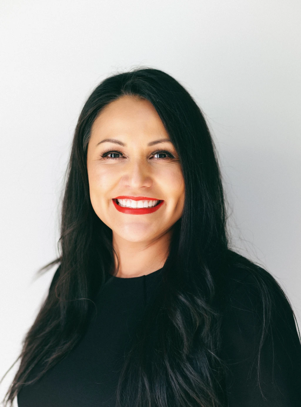 A smiling woman with red lipstick.
